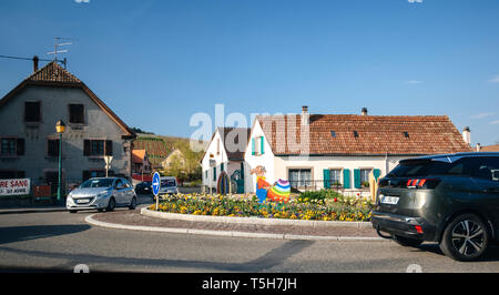 Alsace, France - Apr 19, 2019 : décoration de Pâques sur le rond-point avec caractère Lapin oeuf peinture gris avec fierté les couleurs du drapeau Banque D'Images