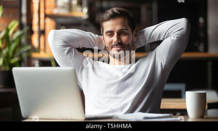 Serene woman sitting at table se sent satisfait l'accomplissement de travaux Banque D'Images