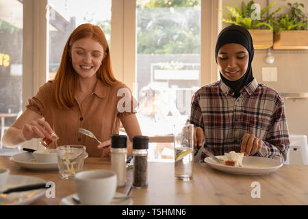 Amies en interaction les uns avec les autres pendant le petit-déjeuner Banque D'Images