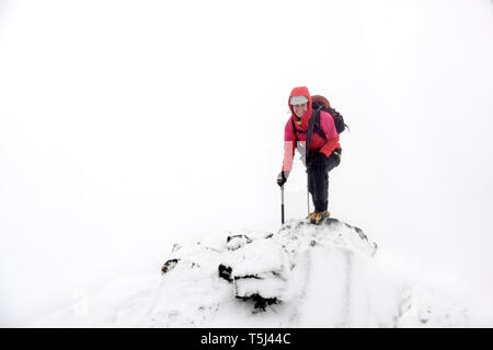 Royaume-uni, Ecosse, Glen Spean, woman climbing crête est un Caorainn de Beinn en hiver Banque D'Images