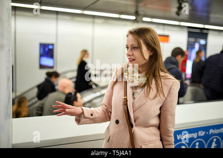 L'Autriche, Vienne, young woman looking at map à la station de métro Banque D'Images