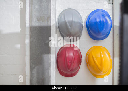 Casques multicolores accroché sur un mur Banque D'Images