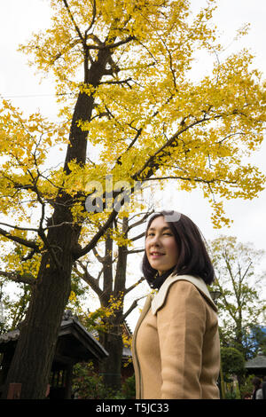 Portrait d'Irene avec automne fond arbres Ginkgo Banque D'Images