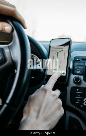 Close-up of woman driving dans une voiture à l'aide d'une application de navigation téléphone Banque D'Images