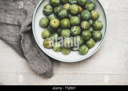 High angle close up d'greengages dans bol blanc. Banque D'Images