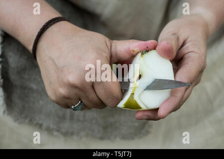 Close up of personne peeling apple avec couteau. Banque D'Images