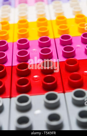 Jouet en plastique fond coloré constructeur. Jouet enfant briques géométriques, Vertical shot. Banque D'Images