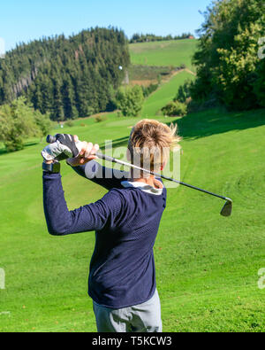 Golfeur Junior hitting ball Banque D'Images