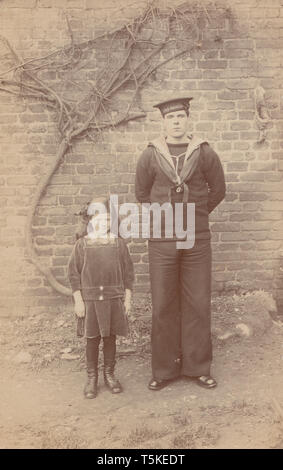 Vintage Carte postale photographique montrant un marin de la Marine royale britannique H.M.S Oreste avec sa petite Sœur. Banque D'Images