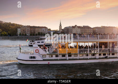 BUDAPEST/Hongrie - 04.21.2019 : Deux navires de croisière, avec une foule de touristes à bord, passer lentement par le Danube au coucher du soleil. Banque D'Images