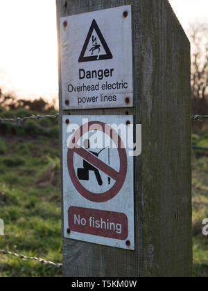 Panneaux d'avertissement de sécurité concernant les lignes électriques et les restrictions de pêche. England UK. Banque D'Images