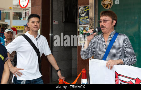 Hong Kong, Hong Kong SAR, Chine. Apr 26, 2019. Le Musée rouvre en 64 Mong Kok Hong Kong. Le musée extérieur manifestant (R) avec un policier en civil sur l'observation (L).A la suite de protestations et la fermeture forcée du musée ouvre à temps pour le 30e anniversaire du massacre de Tiananmen à Beijing, en Chine le 4 juin 1989. L'ouverture, bien qu'entravé par des manifestants pro-Pékin et le vandalisme, attire de nombreux visiteurs, y compris du continent chinois sont souvent pas au courant des événements dénommé 64 événements. Credit : Jayne Russell/ZUMA/Alamy Fil Live News Banque D'Images