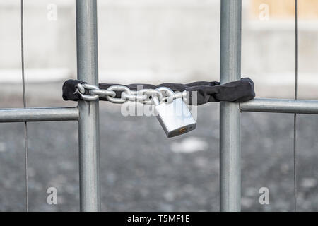 Un cadenas avec chaîne de fixation de la porte d'un chantier de construction. Banque D'Images