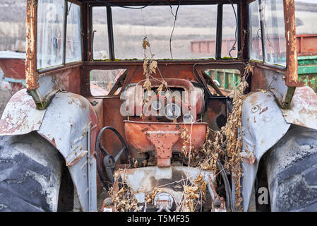 Rusty old red tracteur dans un champ Banque D'Images