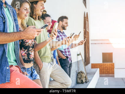 Les jeunes gens à l'écoute sur leurs téléphones mobiles intelligents outdoor - Génération accro à nouveau smartphone technology Banque D'Images