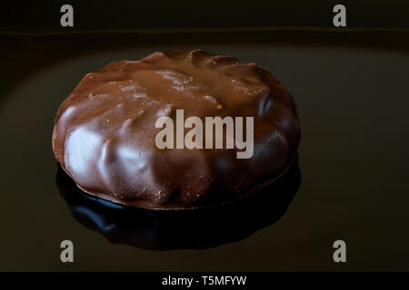 Glaçage au chocolat à la guimauve sur fond noir avec la réflexion. Close up Banque D'Images