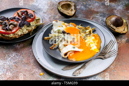 Délicieux petit-déjeuner. Sandwich avec tomates et champignons, l'avocat, oeufs au plat avec les asperges. Banque D'Images
