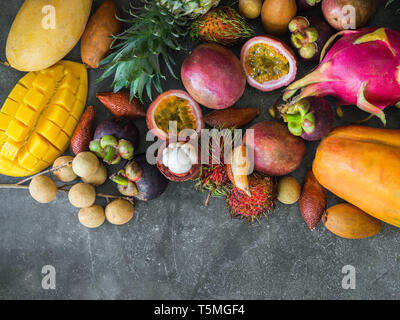 Frais divers fruits thaïlandais - ramboutan, mangue, mangoustan, longan, papaye, fruit du dragon, La sapotille, fruit de la passion, ananas, salak sur un plateau en bois et Banque D'Images