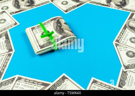 Dollar bills pliée en deux sur fond bleu clair Banque D'Images