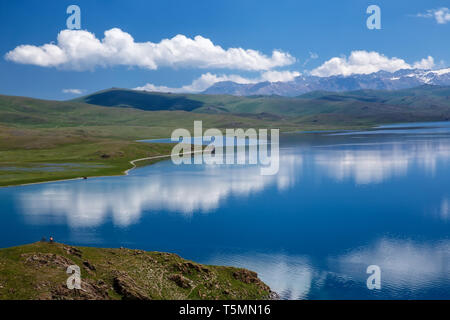 Le ciel avec de beaux nuages reflétée sur la surface d'un lac de montagne. Chanson de montagne lac Kol. Kirghizistan Banque D'Images
