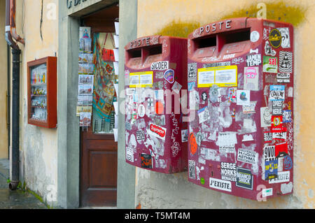 Pise, Italie - 23 avril, 2019 : les boîtes rouge italienne du service postal italien plein d'autocollants à proximité d'une boutique de souvenirs en face du monde famou Banque D'Images