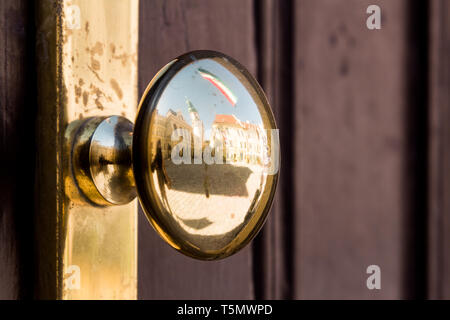 Poignée de porte d'or reflétant la ville intérieure historique de Sopron, Hongrie Banque D'Images