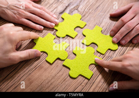 People's Hand Touching Green Puzzle en bois 8 pièces de 24 Banque D'Images