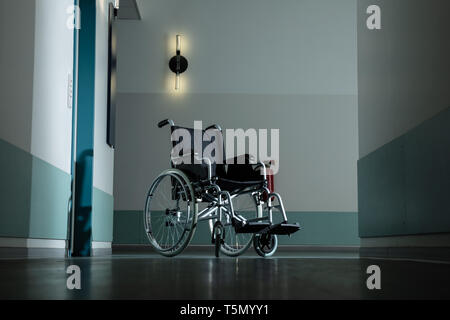 Silhouette de fauteuil roulant vide stationné dans un couloir de l'hôpital Banque D'Images