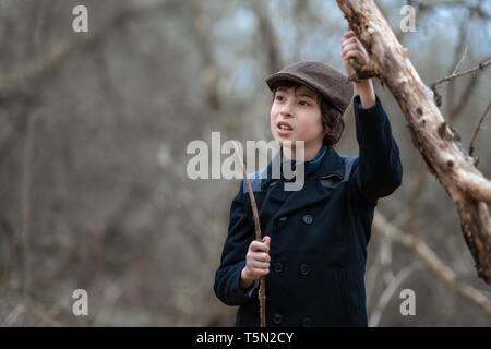 Portrait d'un garçon dans un manteau et d'un cap dans le contexte de la nature. Banque D'Images