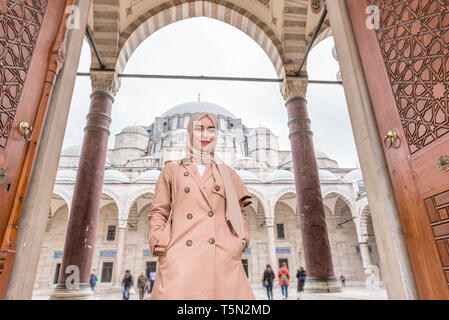 Belle femme musulmane en foulard à la mode et les vêtements à la mode moderne pose à la porte de la mosquée de Soliman à Istanbul, Turquie.la femme musulmane moderne l Banque D'Images