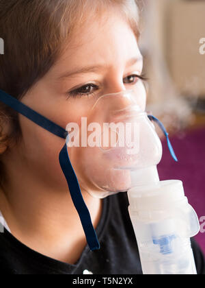 Petite fille de race blanche l'inhalation Inhalateur d'oxygène à la maison Banque D'Images