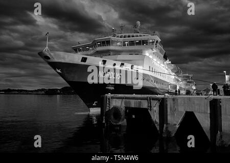 Moody photo noir et blanc du navire Hurtigruten, MS NORDLYS, amarré dans la ville norvégienne de Rorvik, après la tombée de la nuit, Norvège. Banque D'Images