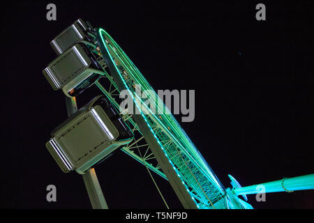 La grande roue d'éclairage en bleu et le vert la nuit. Banque D'Images