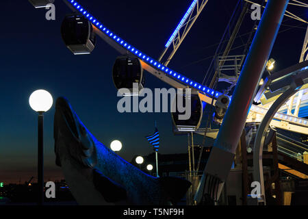 Une grande roue monter sur le bord de l'eau jetée où les panneaux en bois traditionnel sculpture saumon face à Puget Sound à Seattle, USA. Banque D'Images