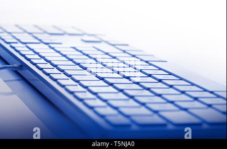 Peu de profondeur de foyer sur clavier contre fond blanc. Se concentrer sur le centre du chemin. Ton bleu Banque D'Images