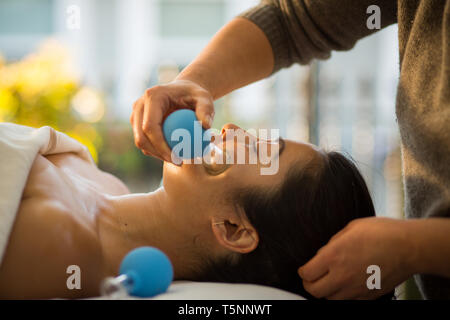 Jeune femme reçoit en cornet de rajeunissement du visage massage du visage à l'acupuncture traitement wellness spa Banque D'Images