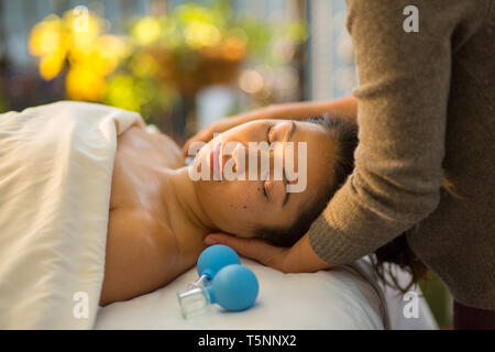 Jeune femme reçoit en cornet de rajeunissement du visage massage du visage à l'acupuncture traitement wellness spa Banque D'Images