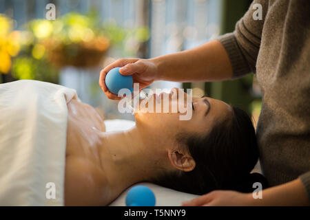 Jeune femme reçoit en cornet de rajeunissement du visage massage du visage à l'acupuncture traitement wellness spa Banque D'Images