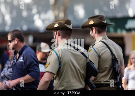 Deux jeunes soldats marchant joyeusement à leur point de rencontre pour l'événement, habillés en uniforme avec leurs chapeaux et les armes à feu Banque D'Images