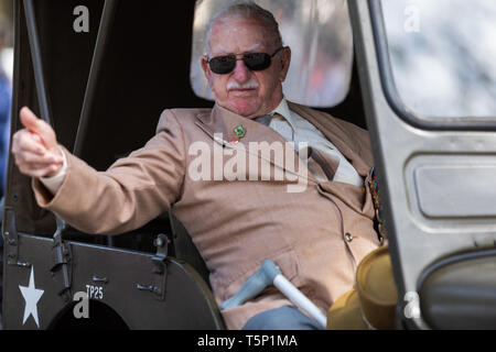 Un vieux vétéran retourné dans son véhicule, gesticulant, giving Thumbs up à la foule acclamant et applaudissant pour lui, lors de l'Anzac Day march Banque D'Images