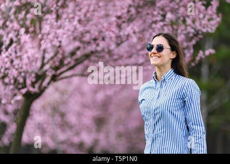 Belle jeune femme dans les fleurs de cerisier en fleurs jardin Banque D'Images