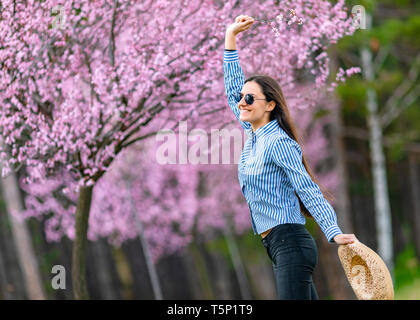 Belle jeune femme dans les fleurs de cerisier en fleurs jardin Banque D'Images