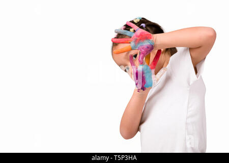 Mignon petit enfant fille aux mains peintes en peinture colorée montre geste d'arrêt isolé sur fond blanc. Banque D'Images