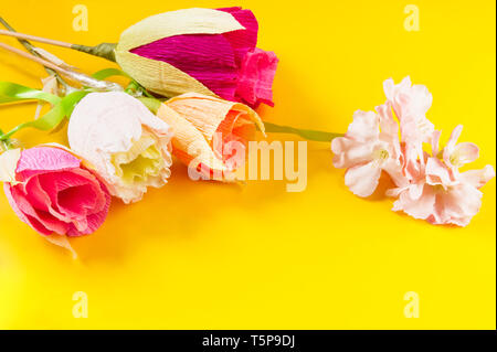 Des fleurs en papier ondulé sur fond jaune Banque D'Images