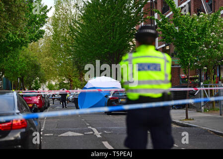 La police à la scène sur Frampton Park Road à Londres après un double coup de poignard. Banque D'Images