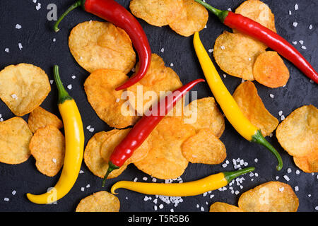 Croustilles de pommes de terre chaudes avec piment rouge et jaune et le sel close up Banque D'Images