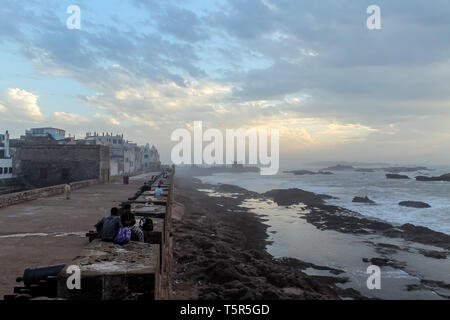 Voir d'Essaouira au coucher du soleil. La vieille partie de la ville est le patrimoine mondial de l'UNESCO. Les touristes et les habitants sont pour le coucher du soleil sur les vieux murs de Banque D'Images