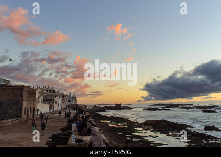 Voir d'Essaouira au coucher du soleil. La vieille partie de la ville est le patrimoine mondial de l'UNESCO. Les touristes et les habitants sont pour le coucher du soleil sur les vieux murs de Banque D'Images