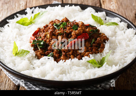 Délicieux avec du poulet basilic piment et sauce soja avec du riz garnir close-up sur une plaque sur la table horizontale. Banque D'Images