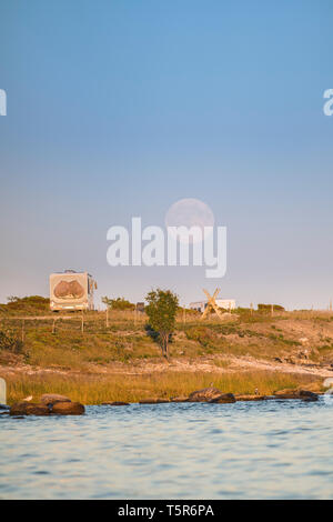 Camper dans la nature, le camping-car stationné sur une plage, dans un beau paysage avec pleine lune derrière, Gotland, Suède, Scandinavie Banque D'Images